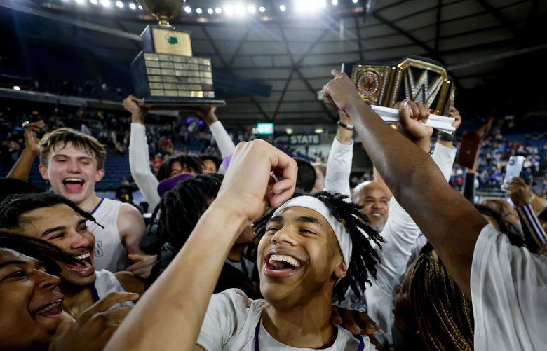 Garfield guard Jamaica Myres, center, celebrates as his teammates hoist the trophy after their 69-50 win over O’Dea for the boys 3A state championship. 223183