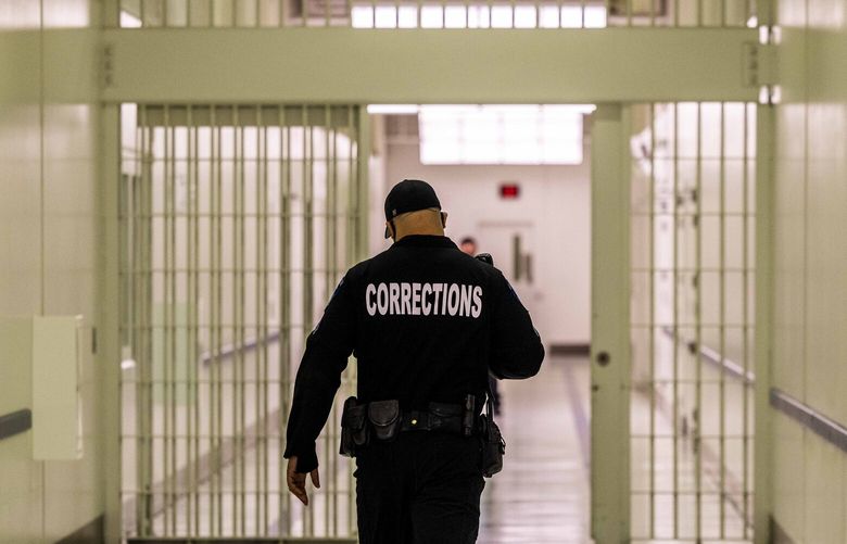 A corrections officer walks down a hallway at SCORE, a jail in Des Moines on Tuesday, Feb. 1, 2022.