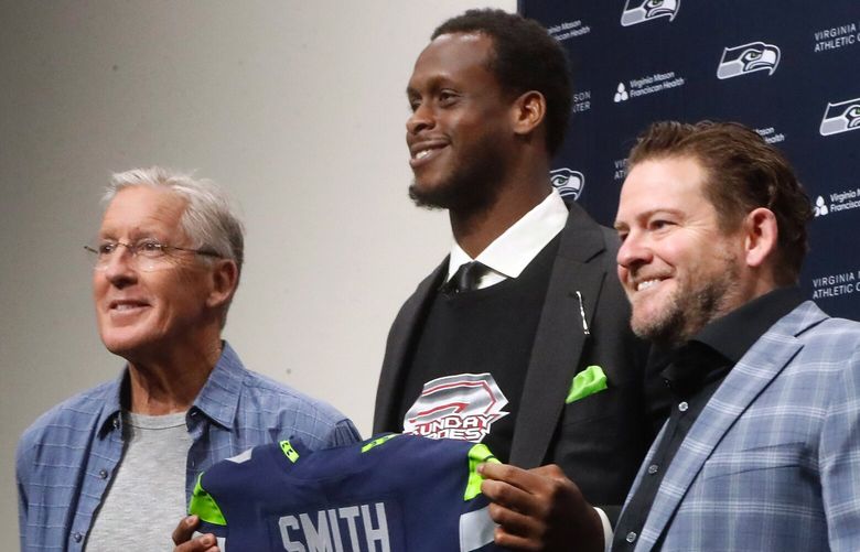 Coach Pete Carroll, left, and Seahawks QB Geno Smith at a media event celebrating Smithâ€™s 3 year contract.
At far right is SeaHawk General Manager John Schneider. 223248