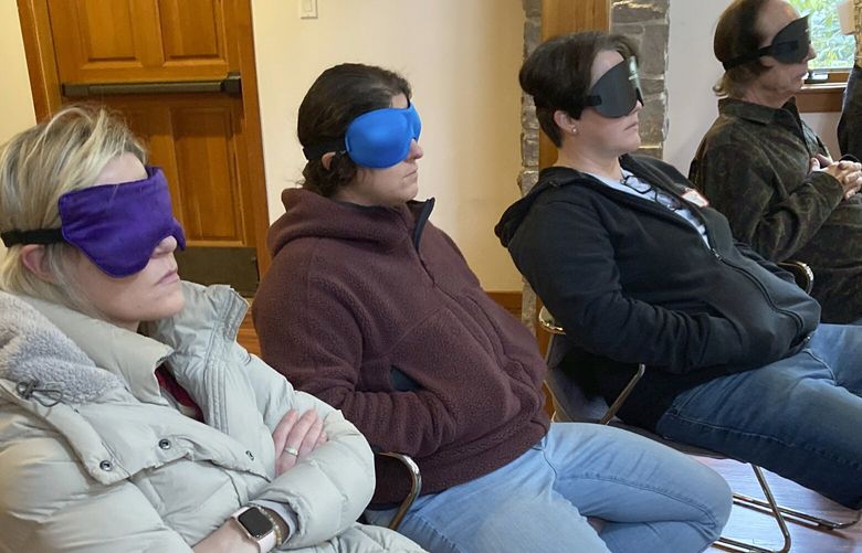 FILE – Psilocybin facilitator students sit with eye masks on while listening to music during an experiential activity at a training session run by InnerTrek near Damascus, Ore., on Dec. 2, 2022. The first students graduate on Friday, March 10, 2023, marking a major step in Oregon’s pioneering role in establishing legal psilocybin therapeutic sessions. The students were trained in how to accompany patients tripping on psilocybin. (AP Photo/Andrew Selsky,File) LA502 LA502