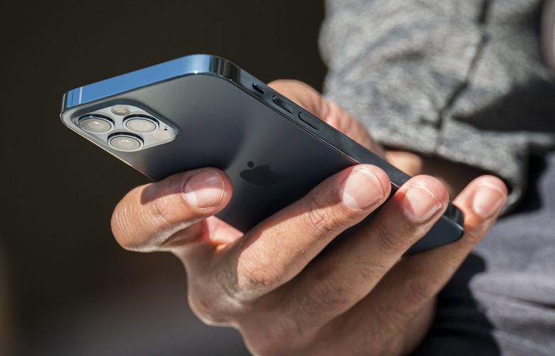 A customer holds a  Apple iPhone 12 Pro at an Apple Inc. store in San Francisco in 2020. (David Paul Morris / Bloomberg)