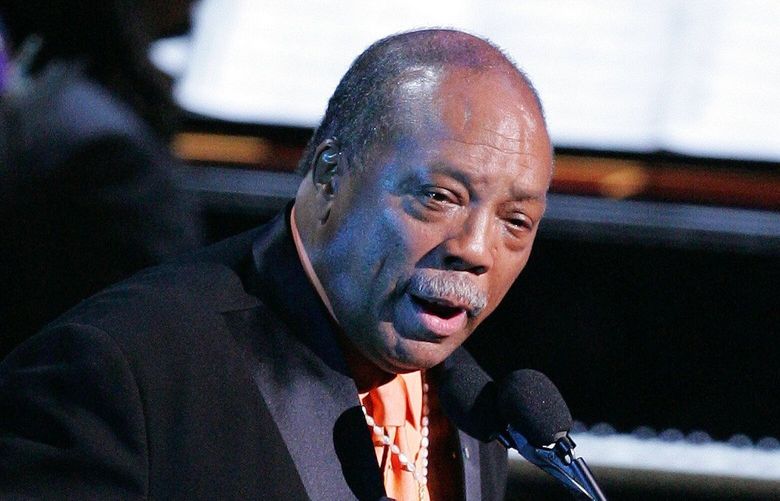 Music producer Quincy Jones holds up a shirt bearing an image of Ray Charles during the taping of a tribute concert to the late singer Friday night, Oct. 8, 2004, in Los Angeles. (AP Photo/Mark J. Terrill) LAS120
