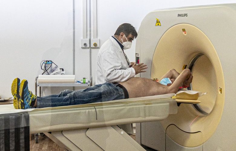 A patient gets a CT scan at an annex of the Pope John XXIII hospital in Bergamo. An expo center had to be turned into a makeshift hospital for coronavirus patients due to a surge of cases in northern Italy in March 2020. MUST CREDIT: Photo for The Washington Post by Alberto Bernasconi.