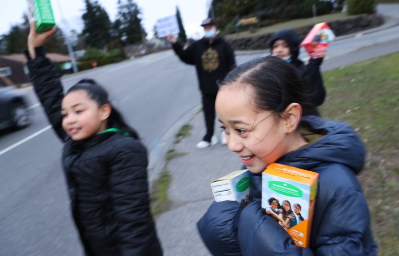 Pauleen Lutui, 8, center, and other girls from Mary’s Place Girl Scout Troop, shout ”Girl Scout Cookies!” To try to get motorists to stop and buy cookies on Ambaum Blvd. in Burien on Thursday, March 9, 2023.