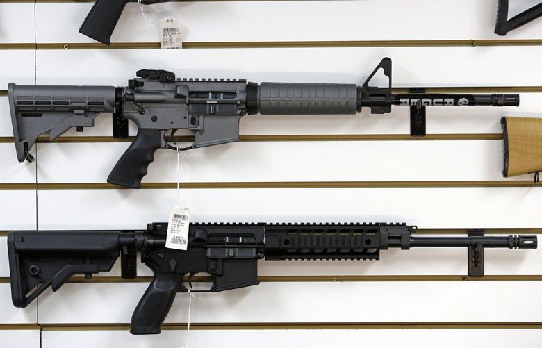 A Ruger AR-15 semi-automatic rifle, center, the same model, though in gray rather than black, used by the shooter in a Texas church massacre two days earlier, sits on display with other rifles on a wall in a gun shop Tuesday, Nov. 7, 2017, in Lynnwood, Wash. Gun-rights supporters have seized on the Texas church massacre as proof of the well-worn saying that the best answer to a bad guy with a gun is a good guy with a gun. Gun-control advocates, meanwhile, say the tragedy shows once more that it is too easy to get a weapon in the U.S. (AP Photo/Elaine Thompson) WAET106