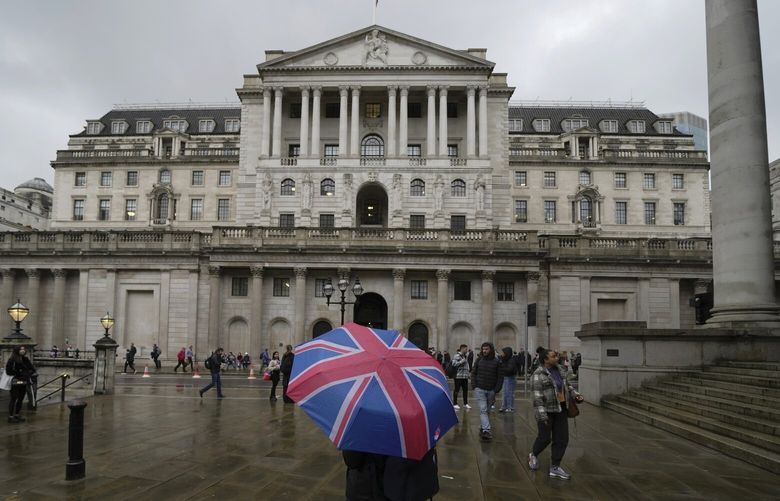 FILE – A woman with an umbrella stands in front of the Bank of England, at the financial district in London, Thursday, Nov. 3, 2022. From winemakers in California to startups across the Atlantic Ocean, companies are scrambling to figure out how to manage their finances after their bank, Silicon Valley Bank, suddenly shut down on Friday, March 10, 2023. The Bank of England said late Friday it would put Silicon Valley Bank UK in its insolvency procedure, which would pay out depositors up to a limit of 170,000 British pounds ($204,544) for joint accounts “as quickly as possible.” (AP Photo/Kin Cheung, File) NYBZ705 NYBZ705
