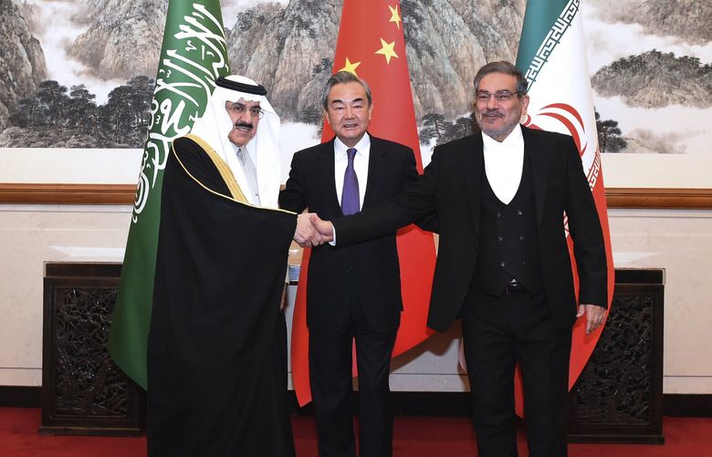 In this photo released by Xinhua News Agency, Ali Shamkhani, the secretary of Iran’s Supreme National Security Council, at right, shakes hands with Saudi national security adviser Musaad bin Mohammed al-Aiban, at left, as Wang Yi, China’s most senior diplomat, looks on, at center, for a photo during a closed meeting held in Beijing, Saturday, March 11, 2023. Iran and Saudi Arabia agreed Friday to reestablish diplomatic relations and reopen embassies after seven years of tensions. The major diplomatic breakthrough negotiated with China lowers the chance of armed conflict between the Mideast rivals, both directly and in proxy conflicts around the region. (Luo Xiaoguang/Xinhua via AP) XIN801 XIN801