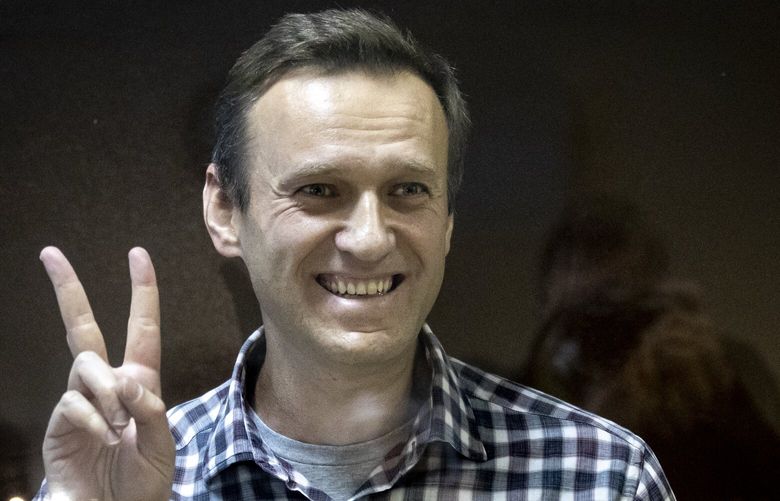 FILE – Russian opposition leader Alexei Navalny gestures as he stands behind a glass panel of a cage in the Babuskinsky District Court in Moscow, Russia, on Feb. 20, 2021. Imprisoned Russian opposition leader Alexei Navalny learned Monday March 13, 2023 from his lawyer that a film detailing his poisoning and political activism won the Oscar for best documentary feature. (AP Photo/Alexander Zemlianichenko, File) XAZ109 XAZ109