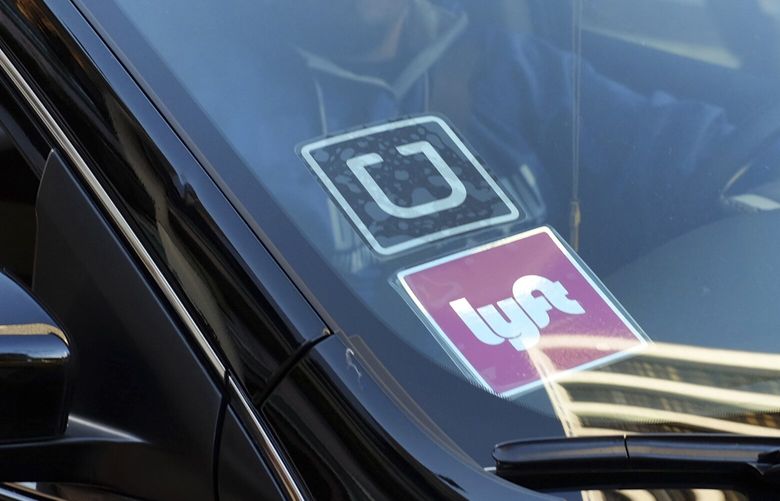 FILE – In this Jan. 12, 2016, file photo, a ride share car displays Lyft and Uber stickers on its front windshield in downtown Los Angeles. A California appeals court ruled Monday, March 13, 2023, that a voter-backed initiative exempting Uber and Lyft from a key provision of state employment law is constitutional, a reversal of a lower court decision that marks a win for the ride-hailing giants. (AP Photo/Richard Vogel, File) 