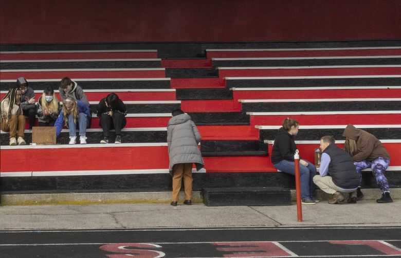 Jeff Rooklidge, a science teacher at Wahkiakum High School, (kneeling at lower right) has students work on science experiments on the bleachers at the high school because there are safety concerns if they do them inside their classroom, shot Wednesday, January 25, 2023.   
  
The Wahkiakum School District is suing the state over the lack of funds it receives to renovate and rebuild its facilities.

The state Supreme Court is about to review the school district’s case against the state which claims  the state isn’t meeting its obligation to fund schools by requiring districts to go through the bond approval system to maintain school building quality. 

 222859