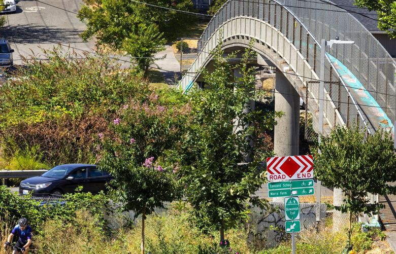A pedestrian bridge crosses over a stretch of Highway 99 cutting through South Park that activists want decommissioned to improve their community is seen Sunday, Aug. 21, 2022 in Seattle. The group got some funding for a study. 221355