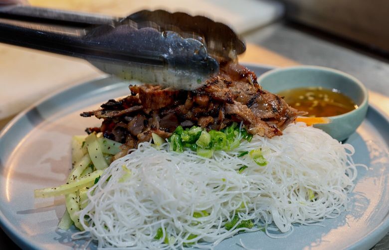 Thinly sliced grilled lemongrass pork collar is placed on a bed of rice noodles, pickles, cucumber, herbs and served with nu?c ch?m to complete the bún th?t nu?ng dish at Lai Rai in Belltown. 223260