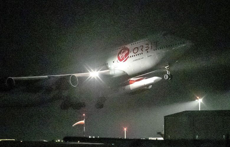FILE – A repurposed Virgin Atlantic Boeing 747 aircraft, named Cosmic Girl, carrying Virgin Orbit’s LauncherOne rocket, takes off from Spaceport Cornwall at Cornwall Airport, Newquay, England, on Jan. 9, 2023. Virgin Orbit said Thursday March 16, 2023 it is pausing all operations amid reports that the company is furloughing almost all its staff as part of a bid to seek a funding lifeline. (Ben Birchall/PA via AP) LGK202 LGK202