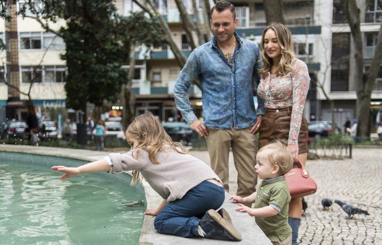 Ben and Megan Mitas at the park with their children in Campo de Ourique, Lisbon, Portugal on March 10, 2023. The Mitas family is part of an influx of Americans moving to European countries. (Kerry Murray/The New York Times)