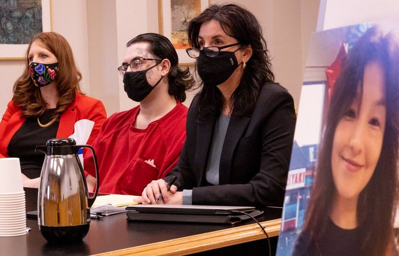 Defense attorneys Emily Gause, wearing red, and Nicole McGrath, wearing black, sit next to client Adnel Kenjar, 22, during his sentencing in King County Superior Court in Seattle Friday, March 17, 2023. A photo of Gabriela Reyes-Dominguez is seen at right. 
 223320