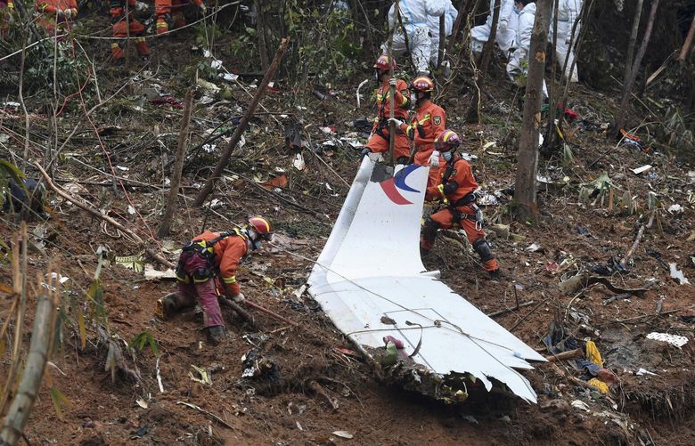 FILE – In this photo released by Xinhua News Agency, search and rescue workers search through debris at the China Eastern flight crash site in Tengxian County in southern China’s Guangxi Zhuang Autonomous Region on March 24, 2022. Experts still are investigating the cause of the crash of a China Eastern Airlines jetliner that plunged into a mountainside one year ago, killing more than hundred people aboard, the government said on Monday, March 20, 2023. (Lu Boan/Xinhua via AP, File) XAW802 XAW802