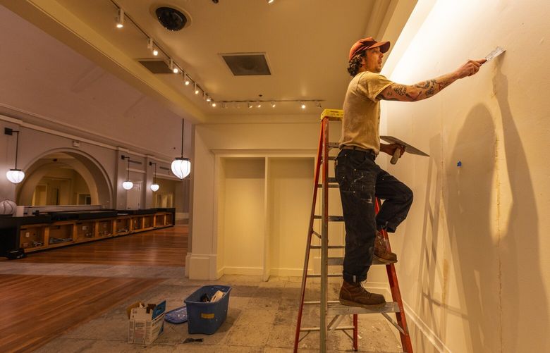 Austin Bellamy Hicks, half of XO Seattle, who fills in some wall cracks, is creating a new art space out of a former downtown Banana Republic store, Monday, March 20, 2023 in Seattle.