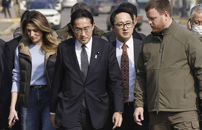 Japanese Prime Minister Fumio Kishida, center, arrives at a church in Bucha, a town outside Kyiv that became a symbol of Russian atrocities against civilians, in Ukraine, Tuesday, March 21, 2023.(Iori Sagisawa/Kyodo News via AP) TKSJ804 TKSJ804