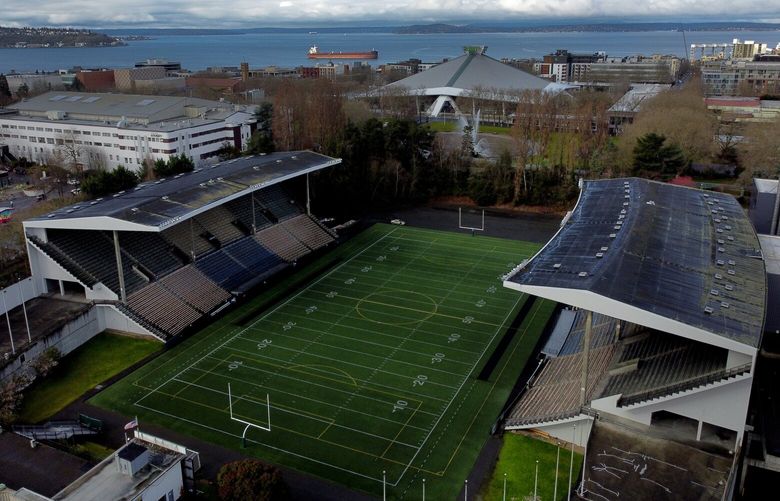 Memorial Stadium is seen from the air, Tuesday, March 21, 2023, in Seattle, with Climate Pledge Arena and Puget Sound in the background. District and city officials are looking for bids to take on the project of tearing down and rebuilding the Memorial Stadium, that has long been owned by Seattle schools.