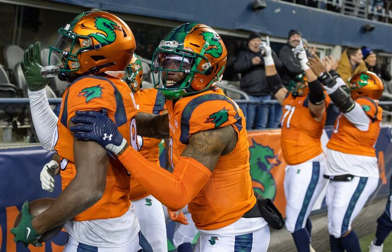 The Sea Dragons celebrate the fourth quarter touchdown by Jordan Veasy, far left, Thursday evening at Lumen Field in Seattle last month.