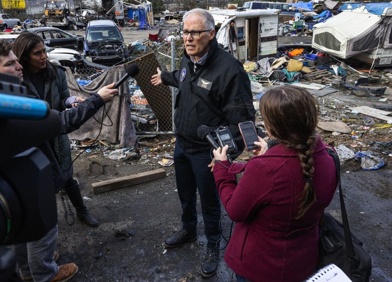 Gov. Jay Inslee went to an encampment under the First Avenue South bridge to say we “do not accept this level of squalor.” But the backstory suggests that we do, columnist Danny Westneat writes. (Ken Lambert / The Seattle Times)
