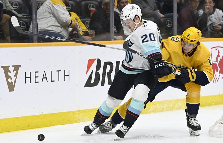 Seattle Kraken right wing Eeli Tolvanen (20) blocks Nashville Predators center Cody Glass from getting to the puck during the first period of an NHL hockey game, Thursday, March 23, 2023, in Nashville, Tenn. (AP Photo/Mark Zaleski)
