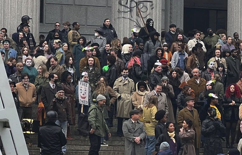 Throngs of actors portraying protesters, some in make-up, gather outside a courthouse for the filming of a scene in the “Joker” movie sequel in New York, Saturday, March 25, 2023. Production crews had to wrestle with the possibility that filming could be disrupted by real-life protests over the Trump case, none of which have materialized so far. (AP Photo/Bobby Caina Calvan) NYBC602 NYBC602