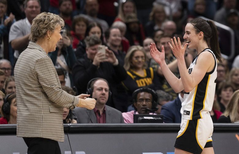 Iowa guard Caitlin Clark, right, and head coach Lisa Bluder celebrate as Clark leaves the floor during the second half of an Elite 8 college basketball game against Louisville in the NCAA Tournament, Sunday, March 26, 2023, in Seattle. Iowa won 97-83. (AP Photo/Stephen Brashear) WASB117 WASB117