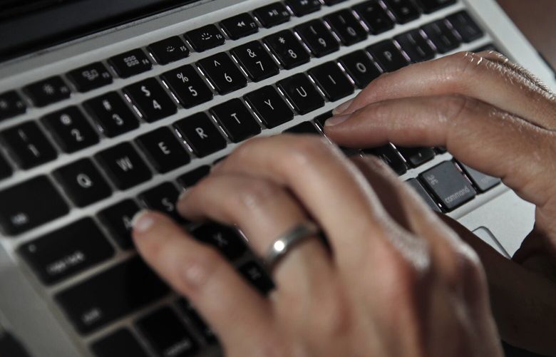 FILE- A person types on a laptop keyboard in North Andover, Mass, June 19, 2017. The U.S. government will restrict its use of commercial spyware tools that have been used to surveil human rights activists, journalists and dissidents around the world, under an executive order issued Monday, Oct. 27, 2023, by President Joe Biden. (AP Photo/Elise Amendola, File) WX103 WX103