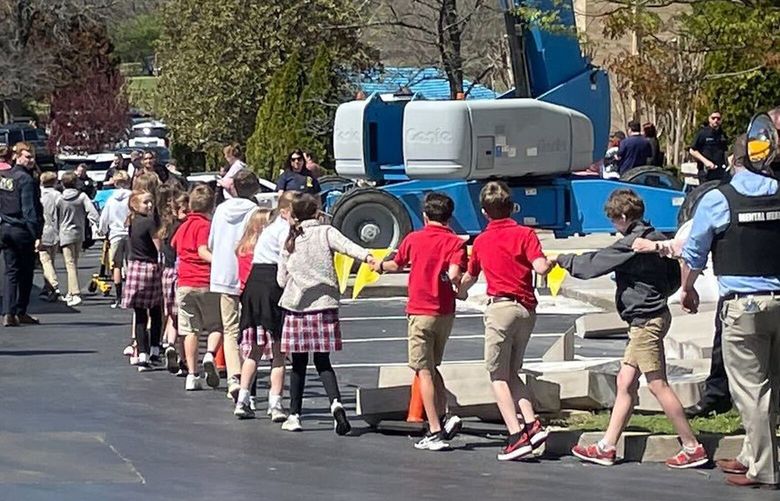 Children from The Covenant School, a private Christian school in Nashville, Tenn., hold hands as they are taken to a reunification site at the Woodmont Baptist Church after a shooting at their school, on Monday March, 27, 2023. (AP Photo/Jonathan Mattise) TNJM103 TNJM103
