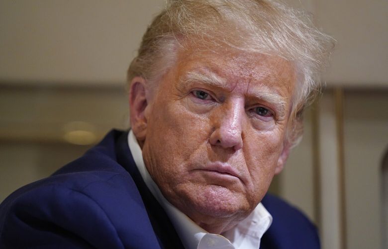 Former President Donald Trump listens as he speaks with reporters while in flight on his plane after a campaign rally at Waco Regional Airport, in Waco, Texas, Saturday, March 25, 2023, while en route to West Palm Beach, Fla. (AP Photo/Evan Vucci) TXEV518 TXEV518
