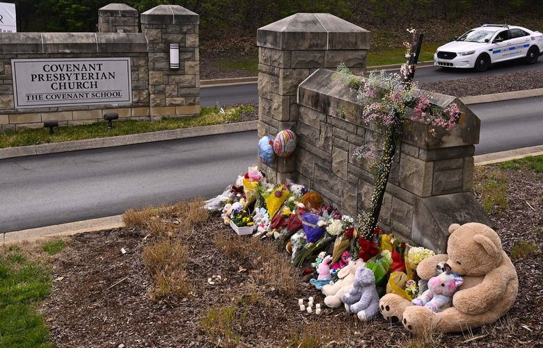 A make shift memorial is seen at the entry to Covenant School with a police car guarding, on Tuesday, March 28, 2023, in Nashville, Tenn. The former student who shot through the doors of the Christian elementary school and killed three children and three adults had drawn a detailed map of the school.  (AP Photo/John Amis) TNJA101 TNJA101