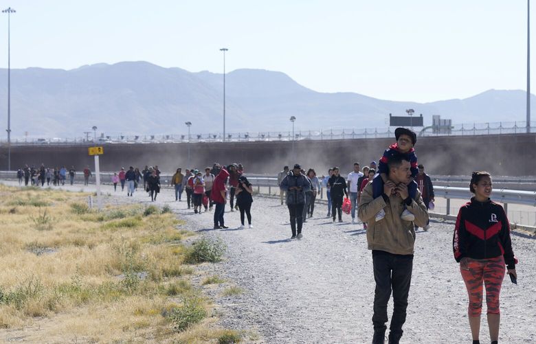 Migrants walk along the Mexico-U.S. border in Ciudad Juarez, Mexico, Wednesday, March 29, 2023, a day after dozens of migrants died in a fire at a migrant detention center in Ciudad Juarez. (AP Photo/Fernando Llano) XFLL261 XFLL261