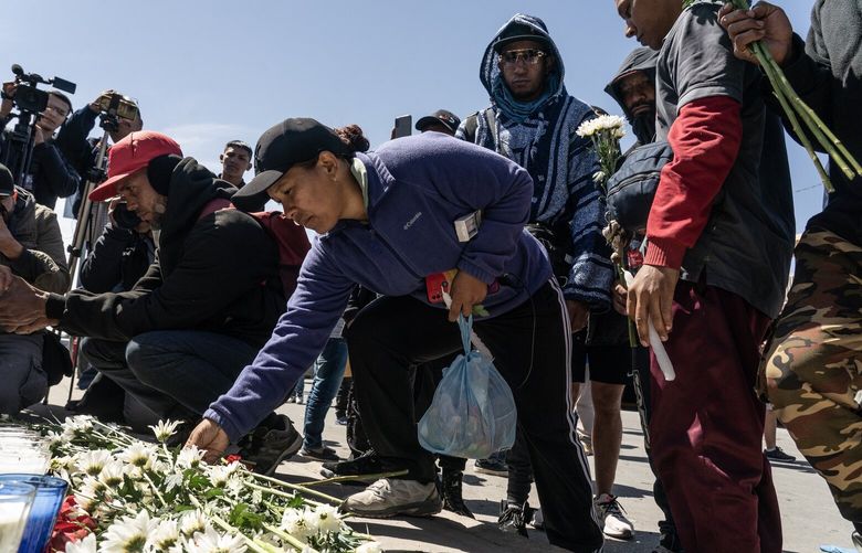 Venezuelan migrants place flowers at a makeshift memorial outside the National Migration Institute building in Ciudad Juárez, Mexico, a border city across from El Paso, Texas, on Tuesday, March 28, 2023. At least 39 people were killed on Monday night and 29 others seriously injured when a fire broke out in the accommodation area of the government-run migration facility in northern Mexico, near the border with the United States, the authorities said. (Go Nakamura/The New York Times) XNYT188 XNYT188