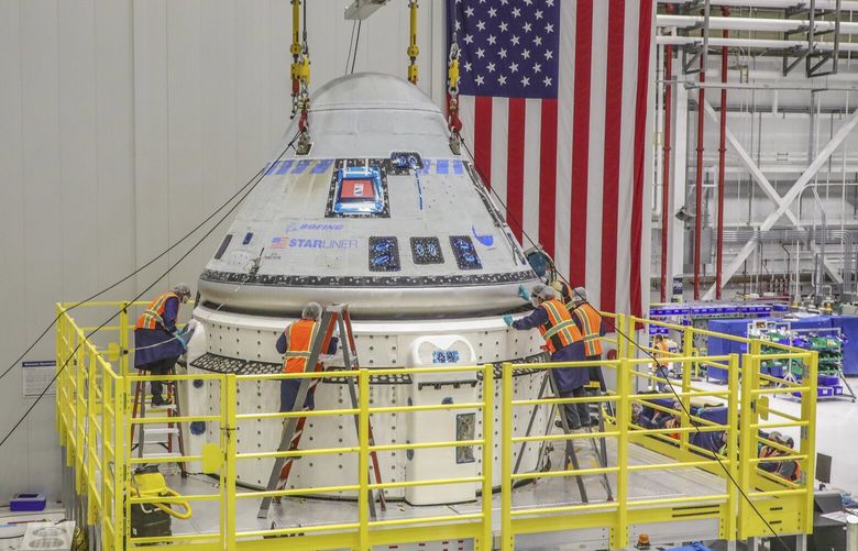 In this photo provided by Boeing, technicians work on the Starliner spacecraft at the Kennedy Space Center in Florida on Jan. 19, 2023, in preparation for NASA’s Boeing Crew Flight Test. (John Grant/Boeing via AP) 