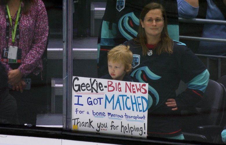 Seattle kindergartener Isola Fiddick, 5, and her mother Tricia had news for Kraken center Morgan Geekie before a game at Climate Pledge Arena on March 18 –  a bone-marrow donor had been found for Isola. They held a sign against the glass during warmups, getting a wave from Geekie once he spotted it. Geekie had recorded a video urging fans to become potential donors.