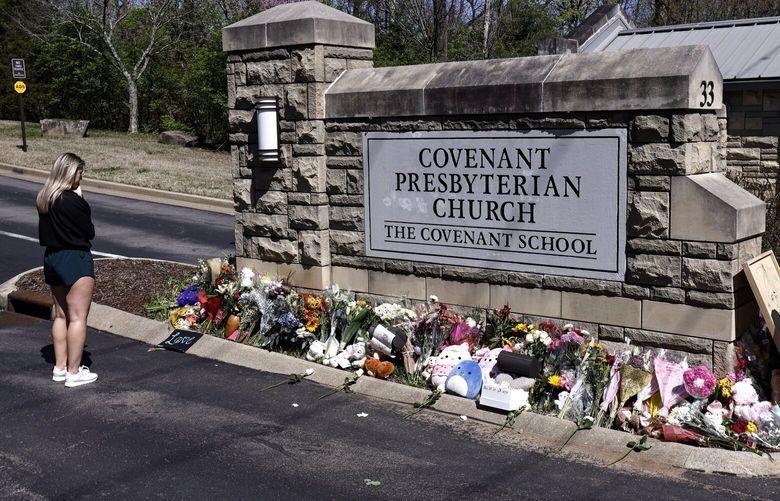 A woman pauses as she visits a memorial at the entrance to The Covenant School on Wednesday, March 29, 2023, in Nashville, Tenn. (AP Photo/Wade Payne) TNWP113 TNWP113