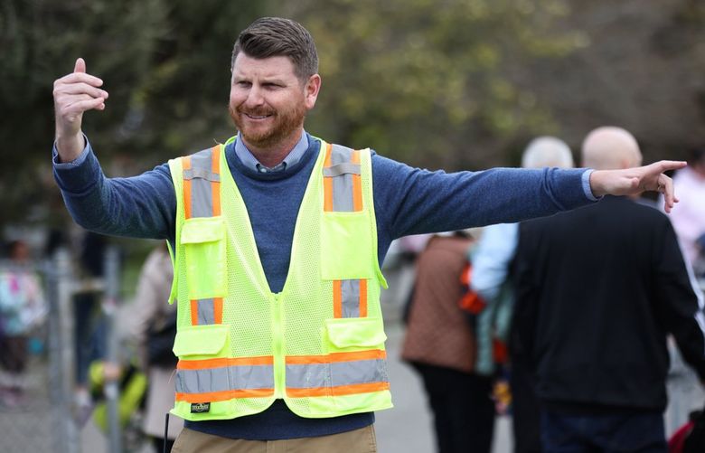 At the end of the school day, Principal Mason Skeffington helps direct traffic and pedestrian crossings at Alki Elementary School Tuesday, March 28, 2023. 
 223393 (Erika Schultz / The Seattle Times)