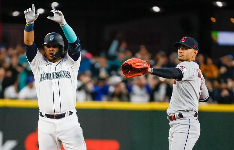 Mariners’  Eugenio Suarez celebrates advancing to second base with Guardians’ Andres Gimenez Thursday evening at T-Mobile Park in Seattle, Washington on March 30, 2023.