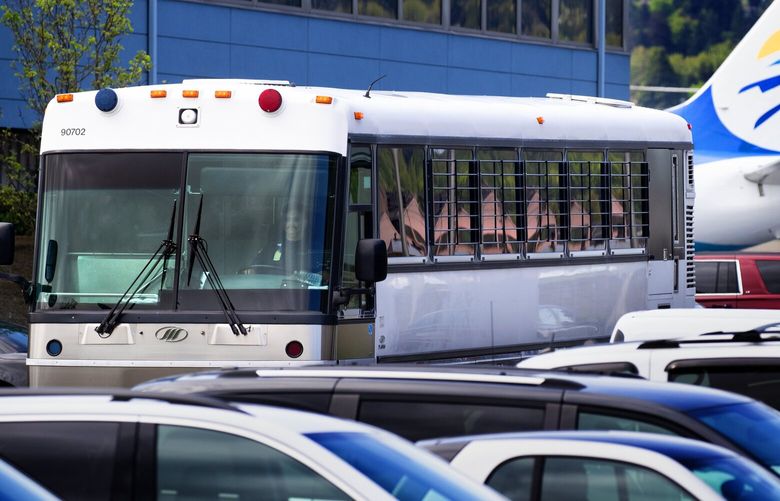 A bus with barred windows carrying detained immigrants from the plane in the background leaves Boeing Field around noon on Tuesday. The charter flight from Phoenix was operated for Immigration and Customs Enforcement (ICE).

Photographed on April, 23, 2019. 210018 210018