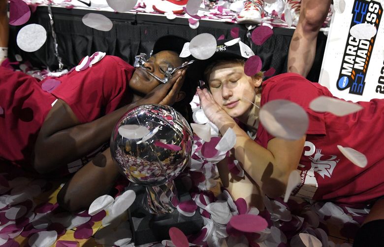 Washington State center Bella Murekatete, left and guard Astera Tuhina pretend to sleep with the championship trophy after the team defeated UCLA in an NCAA college basketball game in the finals of the Pac-12 women’s tournament Sunday, March 5, 2023, in Las Vegas. (AP Photo/David Becker) NVDB118 NVDB118