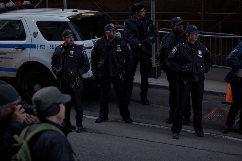 NYPD officers outside the Manhattan Criminal Court after news broke of the indictment of former President Donald Trump, on March 30, 2023. Stepped-up patrols have been visible downtown, and law enforcement officials have been preparing for protests. (Anna Watts / The New York Times)