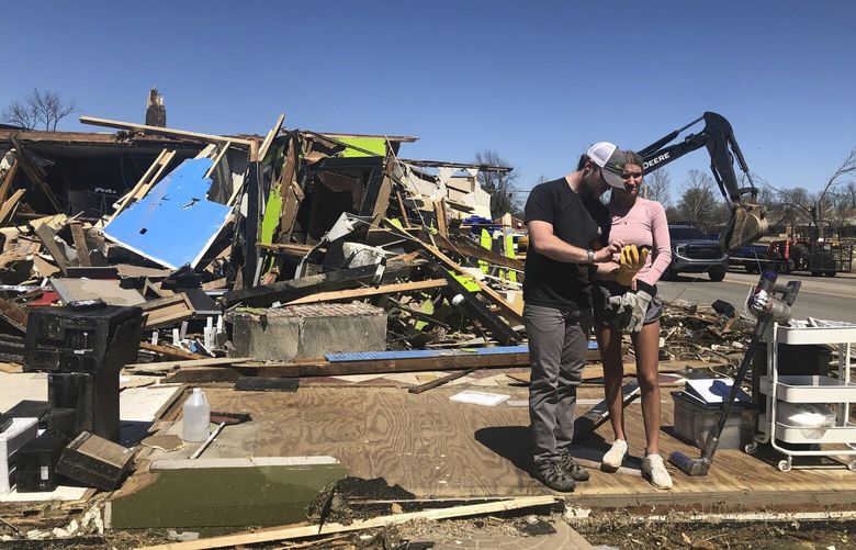Two people stand in front of a destroyed business in Wynne, Ark., on Saturday, April 1, 2023.  Unrelenting tornadoes that tore through parts of the South and Midwest that shredded homes and shopping centers. (AP Photo/Adrian Sainz) RPAS116 RPAS116