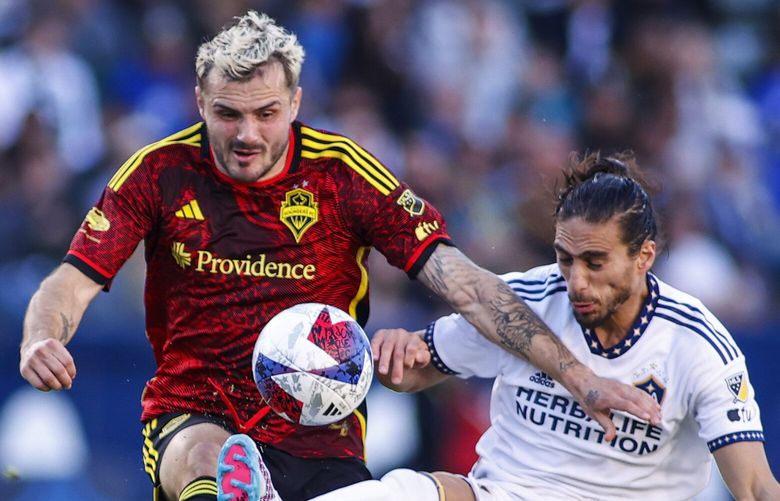 Seattle Sounders forward Jordan Morris, left, and LA Galaxy defender Martín Cáceres vie for the ball during the first half of an MLS soccer match in Carson, Calif., Saturday, April 1, 2023. (AP Photo/Ringo H.W. Chiu) CARC108 CARC108