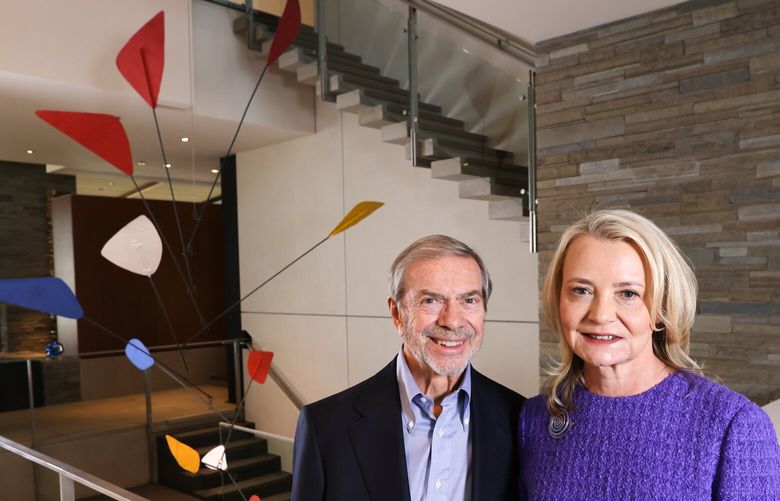 Jon and Kim Shirley, major local philanthropists and art collectors, pose for a photo next to an artwork made in 1969 by Alexander Calder that hangs in a stairwell at their home in Medina on Thursday, March 30, 2023. The artwork had been made for a ballet in Paris called Metaboles. The Shirley’s are donating (bequeathing) their collection of Alexander Calder works to the Seattle Art Museum, on top of a major endowment.