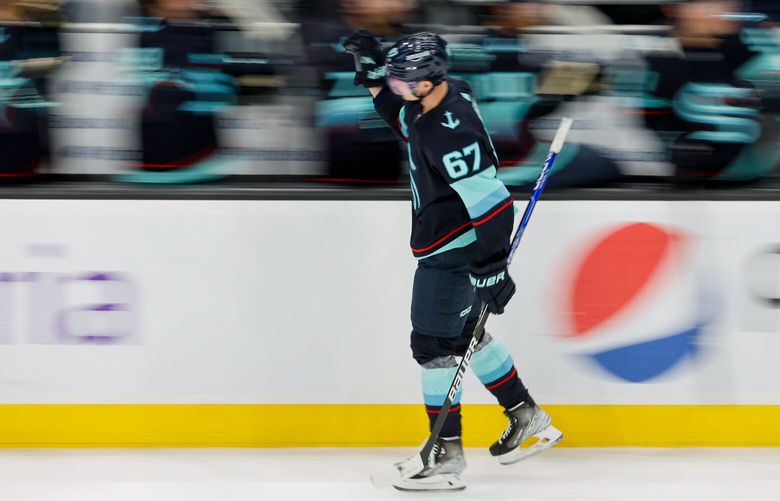 Seattle Kraken center Morgan Geekie high-fives teammates after scoring a goal during the third period. 223406