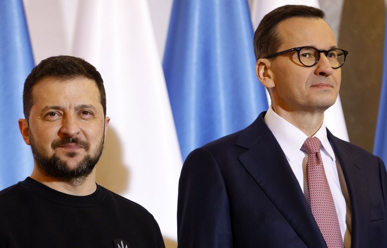 Poland’s Prime Minister Mateusz Morawiecki, right, welcomes Ukrainian President Volodymyr Zelenskyy as they meet in Warsaw, Poland, Wednesday, April 5, 2023. (AP Photo/Michal Dyjuk) PJO131 PJO131