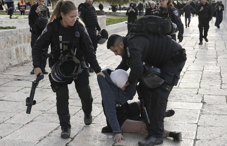 Israeli police arrest a Palestinian woman at the Al-Aqsa Mosque compound following a raid at the site in the Old City of Jerusalem during the Muslim holy month of Ramadan, Wednesday, April 5, 2023. Palestinian media reported police attacked Palestinian worshippers, raising fears of wider tension as Islamic and Jewish holidays overlap.(AP Photo/Mahmoud Illean) XMA128 XMA128