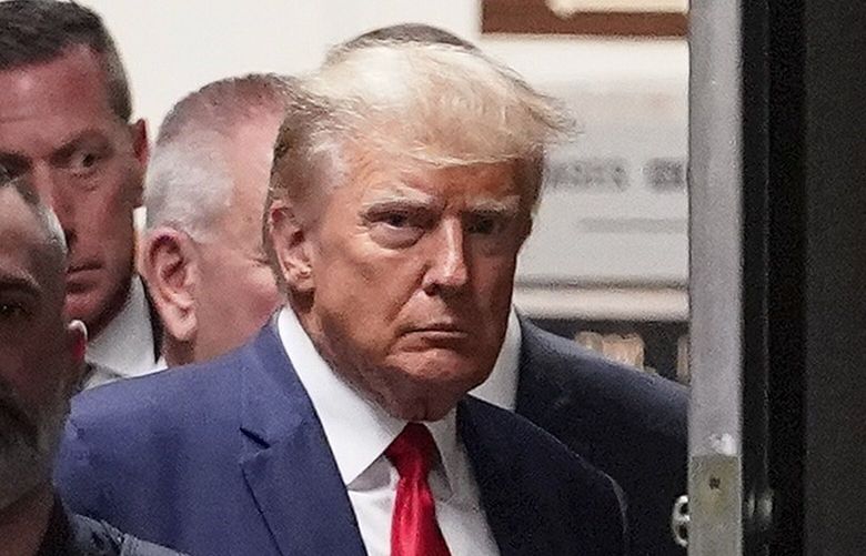 Former President Donald Trump is escorted to a courtroom, Tuesday, April 4, 2023, in New York. The Trump indictment centers on allegations that he falsified internal business records at his private company while trying to cover up an effort to illegally influence the 2016 election by arranging payments that silenced claims potentially harmful to his candidacy. (AP Photo/Mary Altaffer) PNA101 PNA101