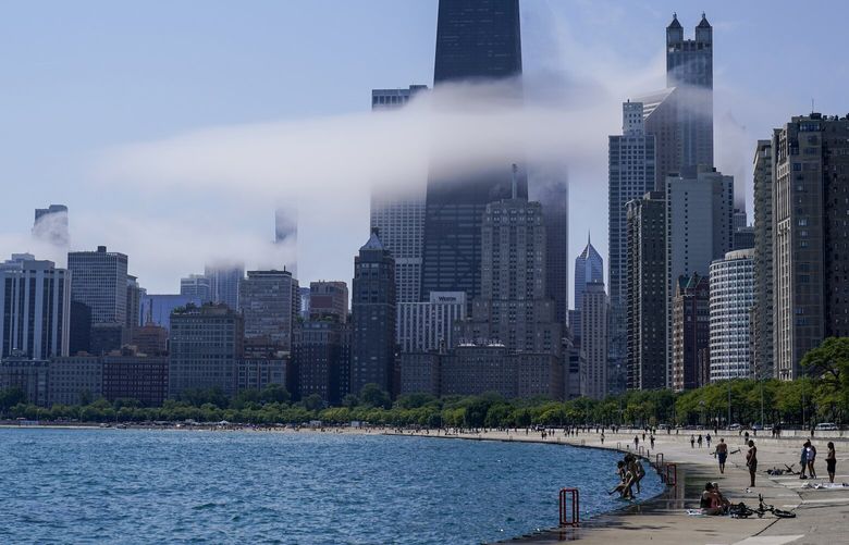 The Chicago city skyline is covered by the fog lifted off Lake Michigan on Aug. 5, 2022, in Chicago. Democrats have chosen Chicago to host their 2024 national convention. (AP Photo/Kiichiro Sato, File) WX104 WX104